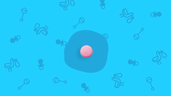 A pink pill on a background of baby rattles represents Amitriptyline and pregnancy