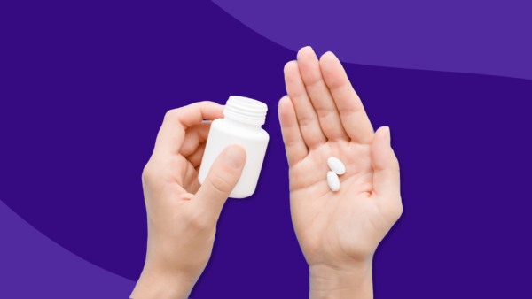 Hand holding Rx pills and and Rx pill bottle: Rybelsus side effects and how to avoid them