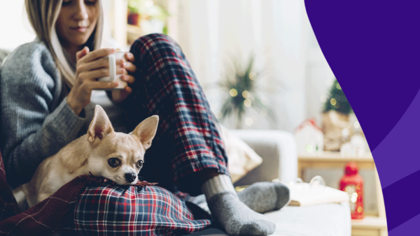 Woman holding mug with dog on lap: Symptoms of fibromyalgia