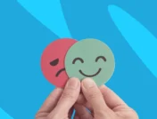 Hands holding a sad face and a happy face | How to identify the symptoms of anxiety and depression