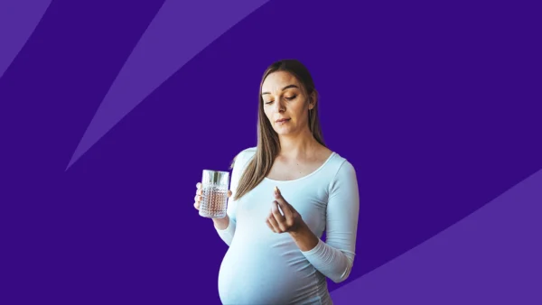 pregnant person holding up a pill - omeprazole pregnancy