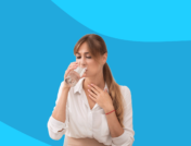 Someone holding lightly touching their neck and drinking water: Sulfur burps: Causes and treatment