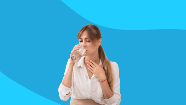 Someone holding lightly touching their neck and drinking water: Sulfur burps: Causes and treatment