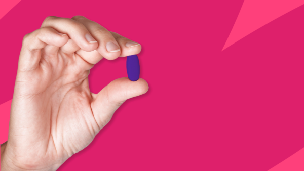 A hand holding a purple pill: How to save on Rinvoq