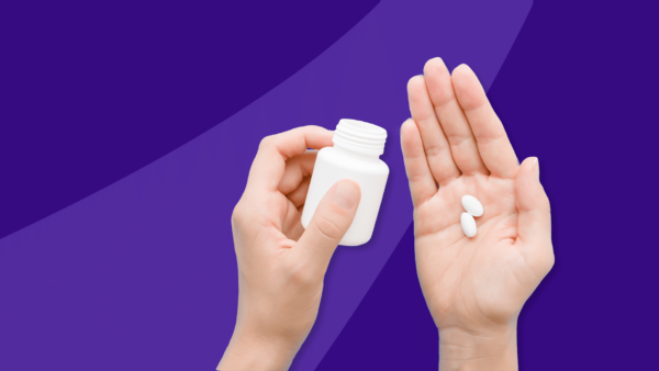 A hand holding two Rx pills: How does hydroxychloroquine work for Lupus?