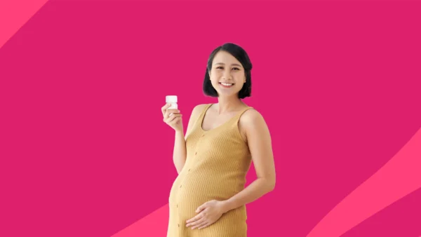 A woman holding a bottle of pills | Nurtec and pregnancy