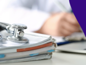 A stack of books with a stethoscope on it and a healthcare provider writing something in the background: Is compounded semaglutide safe?