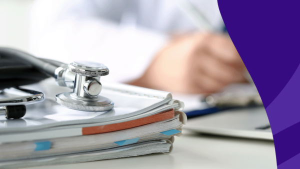 A stack of books with a stethoscope on it and a healthcare provider writing something in the background: Is compounded semaglutide safe?