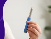A hand holding an injector pen | Do the side effects of Wegovy go away?