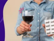 A person holding a glass of wine and pills | Wellbutrin and alcohol