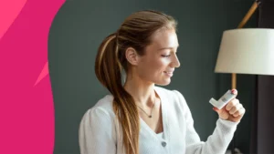image of a woman smiling and holding an inhaler - inhalers for COPD