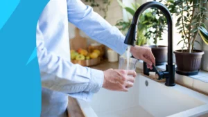 Person filling a glass of water at the faucet - Do antibiotics make you thirsty?
