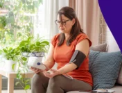 Woman seated at a window looking at a medication bottle - Does Adderall raise blood pressure?