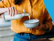 Person pouring milk into a bowl - best milk for diabetics