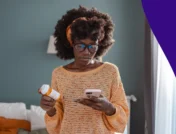 A woman looking at her phone and a pill bottle | How soon after taking prednisone can I take ibuprofen?