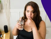 A woman taking a piill | Does prednisone make you sweat?