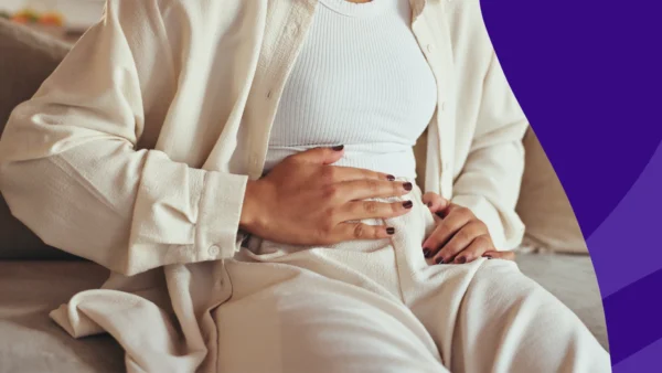 A woman holding her abdomen | Does metformin cause constipation?