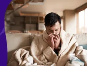 A man who is taking amoxicillin for sinus infection blowing his nose