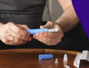Hands holding a Mounjaro vial - when to increase Mounjaro dose for weight loss