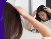 A woman looking at her hair in the mirror | Does Vyvanse cause hair loss?