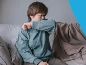 A woman covering a cough with her elbow | Does lisinopril cause a cough?