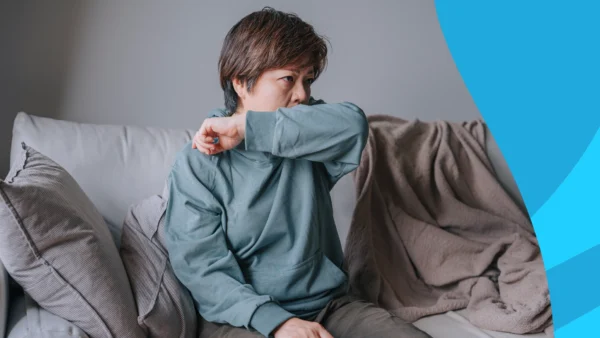 A woman covering a cough with her elbow | Does lisinopril cause a cough?