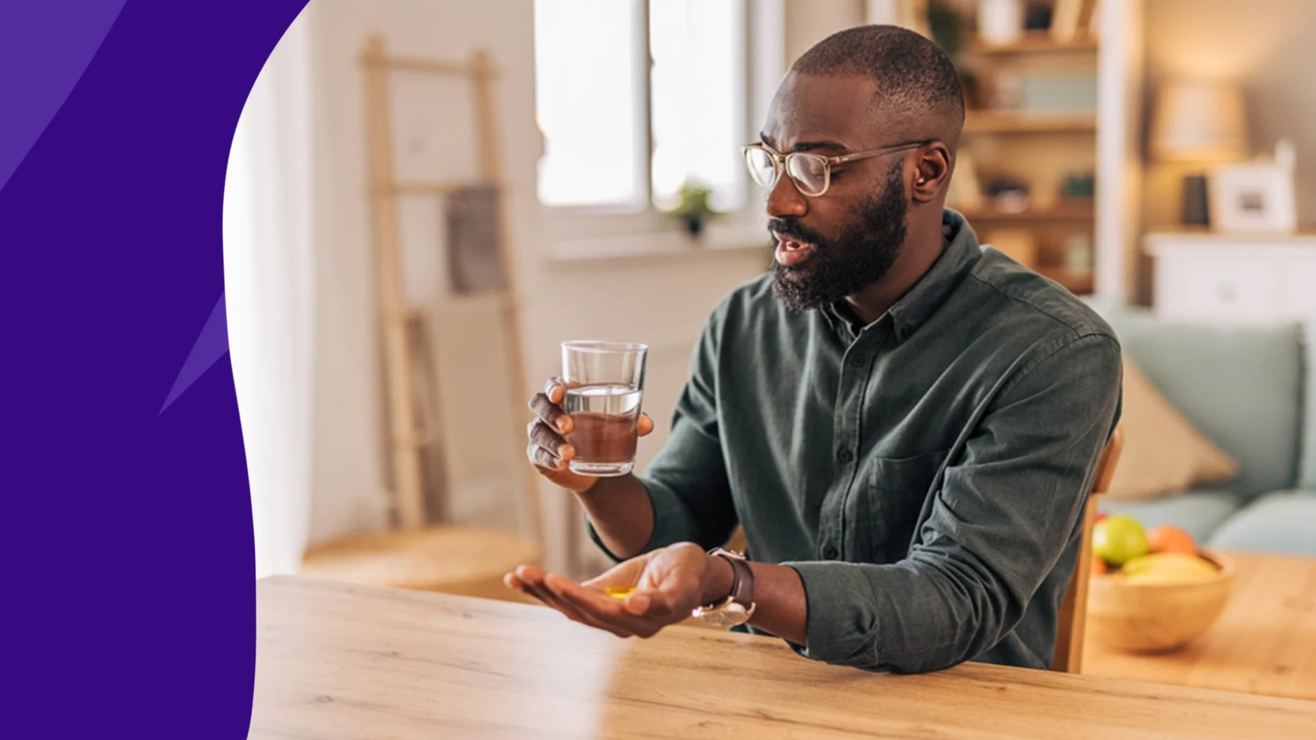 Image of a man with a glass of water and a vitamin E capsule in his hand - vitamin E benefits for men