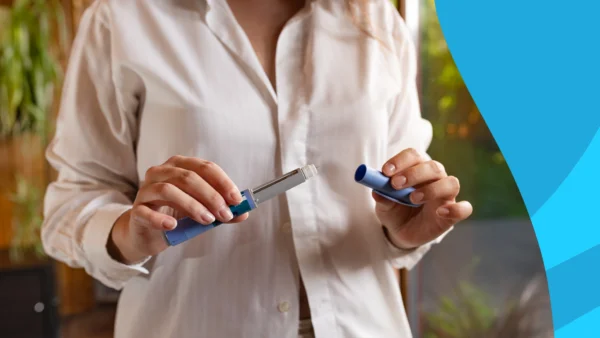 A woman with a GLP-1 pen | Does Mounjaro make you tired?