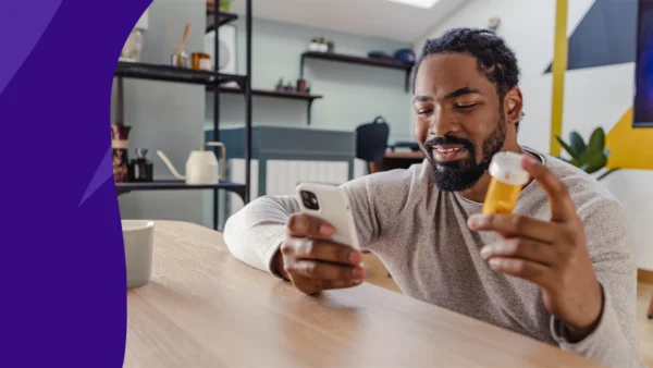 A man looking at his phone and a prescription bottle | How long does lisinopril stay in your system?