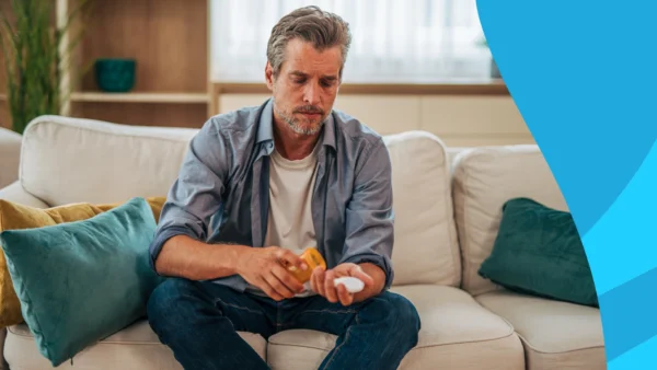 A man sitting on a couch taking tadalafil daily