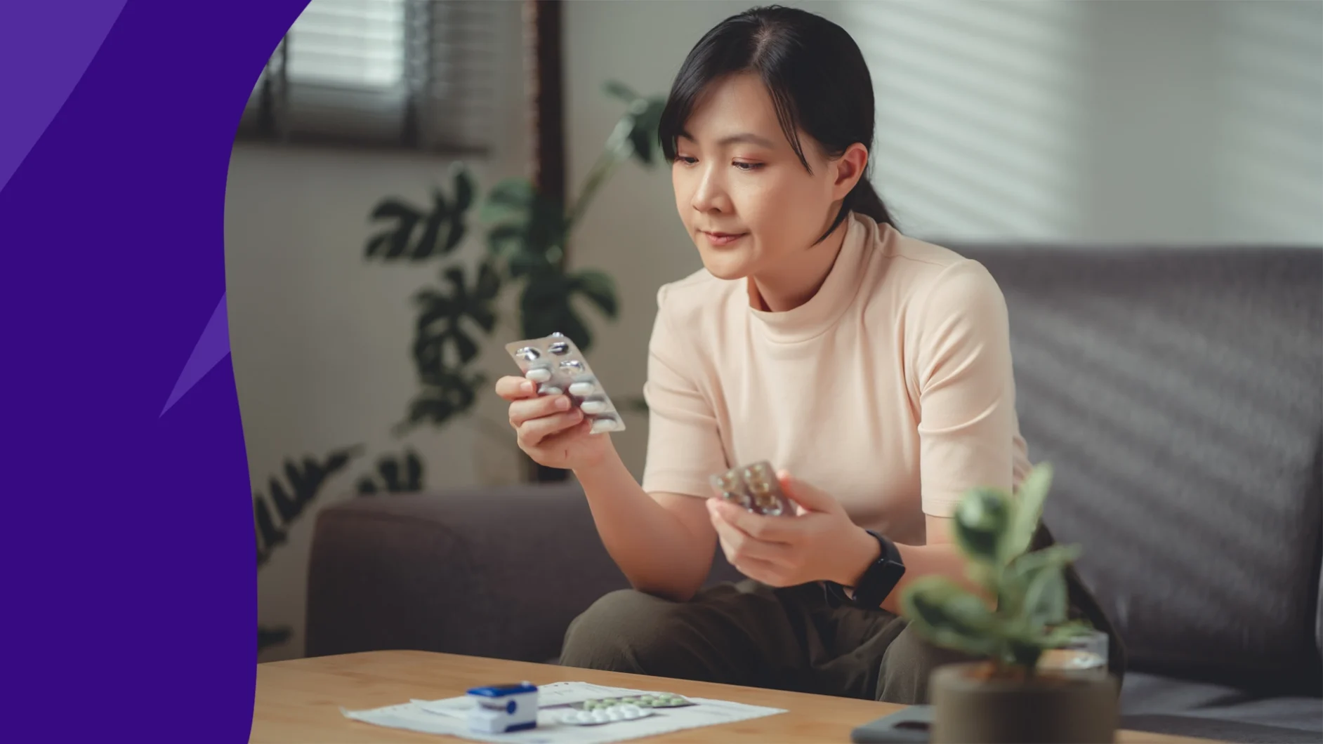 Woman sitting at a table and holding two medication bottles - trazodone and Benadryl