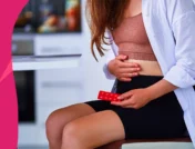 Image a woman with her hand on her abdomen to symbolize increased risk of UTIs during the summer