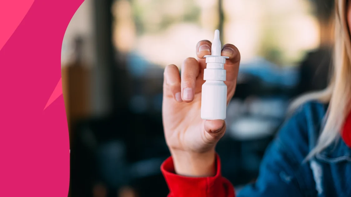Image of a hand holding a bottle of nasal spray to represent Astepro vs. Flonase