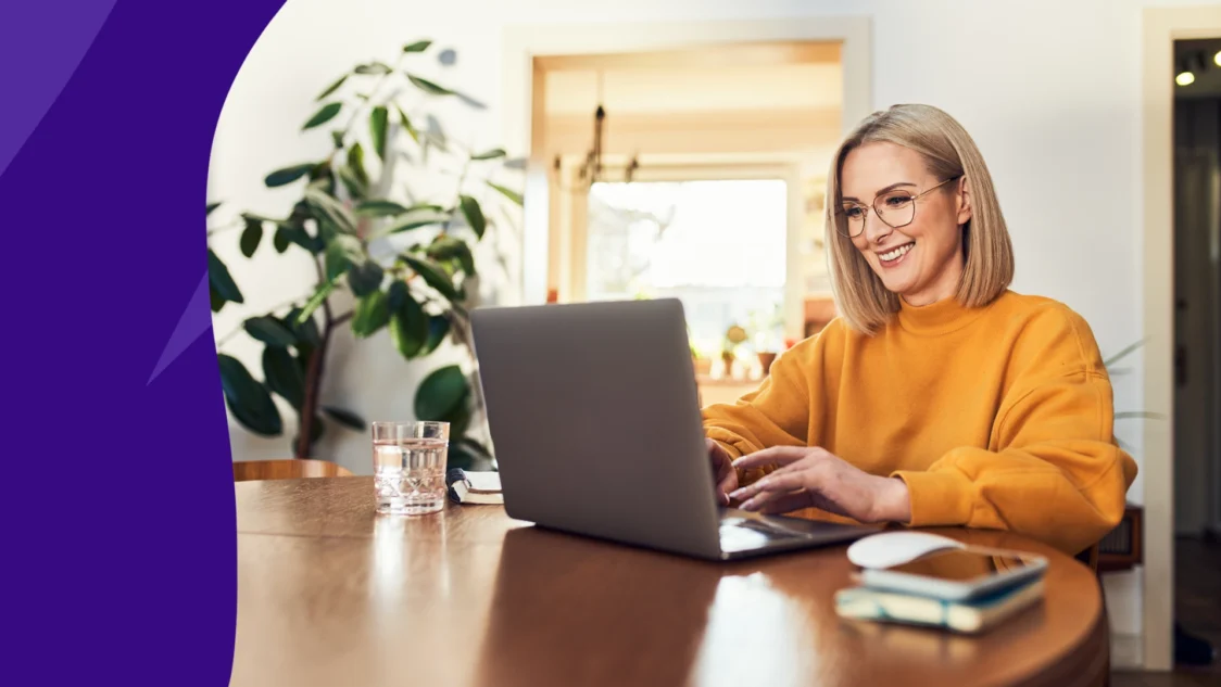 Image of a woman looking at her computer reading SingleCare Trustpilot reviews