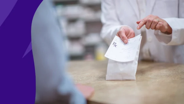 A pharmacist handing a prescription bag to a customer: How much is Foundayo without insurance?